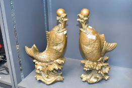 A pair of large Chinese cast patinated Koi fish.each modelled leaping and supporting a pearl on a