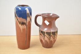 An earthenware brown pitcher decorated with wavy drip glaze patterns, h19cm, sold together with a