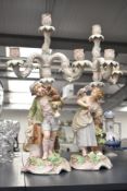 A pair of Meissen style porcelain 5 branch candelabras with figural bases, each hand painted in