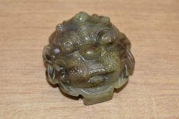 A Chinese carved variegated green stone belt buckle, nicely carved as a mythical creatures mask,