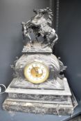 A late 19th century spelter mantel clock having brass and enamel dial, the top decorated with man