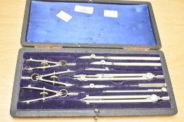 An early 20th century Cartographer's / drawing instrument set, having 11 pieces within a rich blue