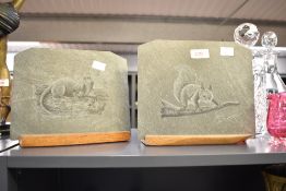 A slate plaque mounted on an oak base, engraved with squirrel on branch, signed Adrian Lewis-