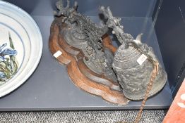 A Victorian/Edwardian oak mounted cast brass door bell, the putto surmounted pierced scrolling