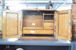A 20th century oak table top stationery box having fitted compartments with working lock and key,