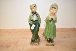 A pair of vintage chalk ware figures of Dutch boy and girl, wearing green garments, h25cm