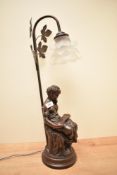 A reproduction cast bronze effect resin figural table lamp, the arched branch with foliate detail