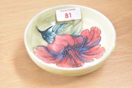 A Moorcroft pottery Hibiscus pattern footed trinket dish, having a yellow-green ground, 11.5cm