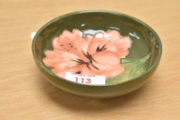 A Moorcroft pottery footed Hibiscus pattern trinket dish, having green glaze, impressed mark to