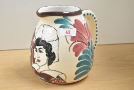 A ceramic jug decorated with male and female figures and foliage on a cream glaze ground, h15cm