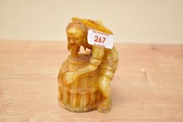 A Chinese hard stone figure carved in the form of a man with basket, signed to base, h12.5cm