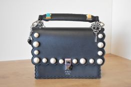 A Fendi Kan handbag in black leather with scalloped edge and plastic oversize pearl detail. pastel