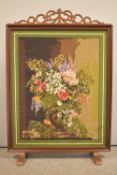 A vintage hardwood fire guard with a cross stitch panel containing a Margot de Paris floral still