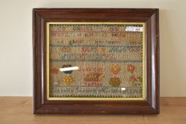 A framed cross stitch sampler, by Isabella Soskirk aged 11, dated 1884, worked mostly in red and