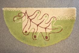 A vintage half moon fire side mat, latch hook woven in green and grey with a brown oak leaf motif.