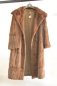 A vintage fur coat, 3/4 length, in warm brown coney, measuring 22' from pit to pit.