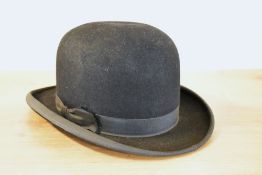 An antique bowler hat in black felt with leather inner brim, with local interest; inside gold foil
