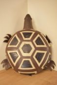 A vintage foot rest in the shape of a tortoise / turtle, constructed with brown, beige and moc-