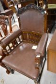 A late 19th or early 20th Century oak and leather armchair