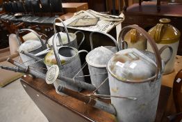 Five assorted galvanised watering cans