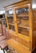 An Ercol golden dawn bookcase with cocktail section over double drawer and cupboard base, dimensions