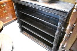 A 19th Century carved oak bookshelf having mask and fruit decoration to supports, width approx.
