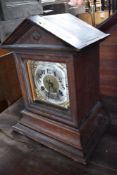 A 19th Century oak cased mantel clock of architectural form with brass and silvered dial, worn