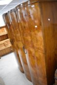 An Art Deco walnut wardrobe, having triple shaped doors, with partially fitted interior, width