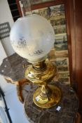 A Victorian brass oil lamp having glass chimney and opaque spherical shade