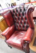 A red leather button back wing armchair