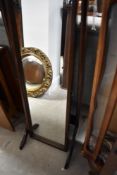 A vintage dark stained cheval mirror