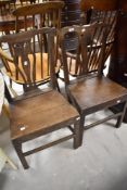 A pair of period oak solid seat dining or hall chairs