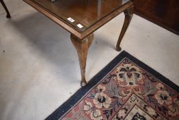 An early to mid 20th Century mahogany coffee table having glass top and cabriole legs, approx. 109 x