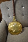 A traditional copper and brass warming pan