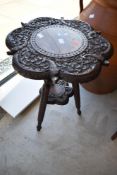 A 19th Century occasional table, heavily carved animalistic and foliate decoration, on tripod