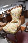 A late 19th or early 20th century mahogany framed nursing chair having fruit upholstery