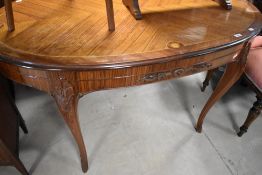A continental style oval dining table, having quarter veneer and inlay style top, with applique