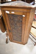 A 19th Century carved corner cupboard of slim proportions with carved vine decoration to door panel,