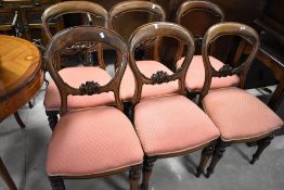 A set of six Victorian mahogany balloon back dining chairs with later upholstery to overstuffed