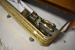 A Victorian pierced brass fire fender and selection of fire tools