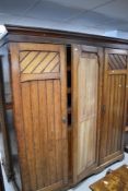 A Victorian pitch pine triple wardrobe/linen press having un-mirrored centre door, width approx.