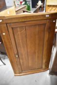 A 19th Century oak corner cupboard , in a light stain, height approx. 121cm