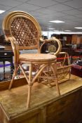 A vintage wicker armchair and magazine rack