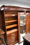 A Victorian mahogany triple wardrobe/linen press having central mirror section and fitted
