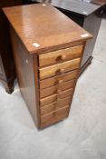 A vintage golden oak narrow chest of seven graduated drawers on castors, dimensions approx. W30