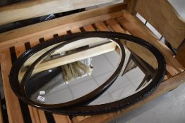 Two vintage oval wall mirrors, oak and mahogany