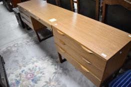 A vintage laminate teak effect bedroom unit comprising two drawer units and centre dressing