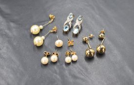 A selection of yellow metal earrings for pierced ears, including diamond chip and topaz drops,