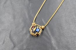 A Michaela Frey gold plated enamelled cross pendant with chain, the cross having a Mondrian style