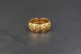 An 18ct gold band, having decorative engraving, marked 18 with hallmarks, ring size L, 5.1g